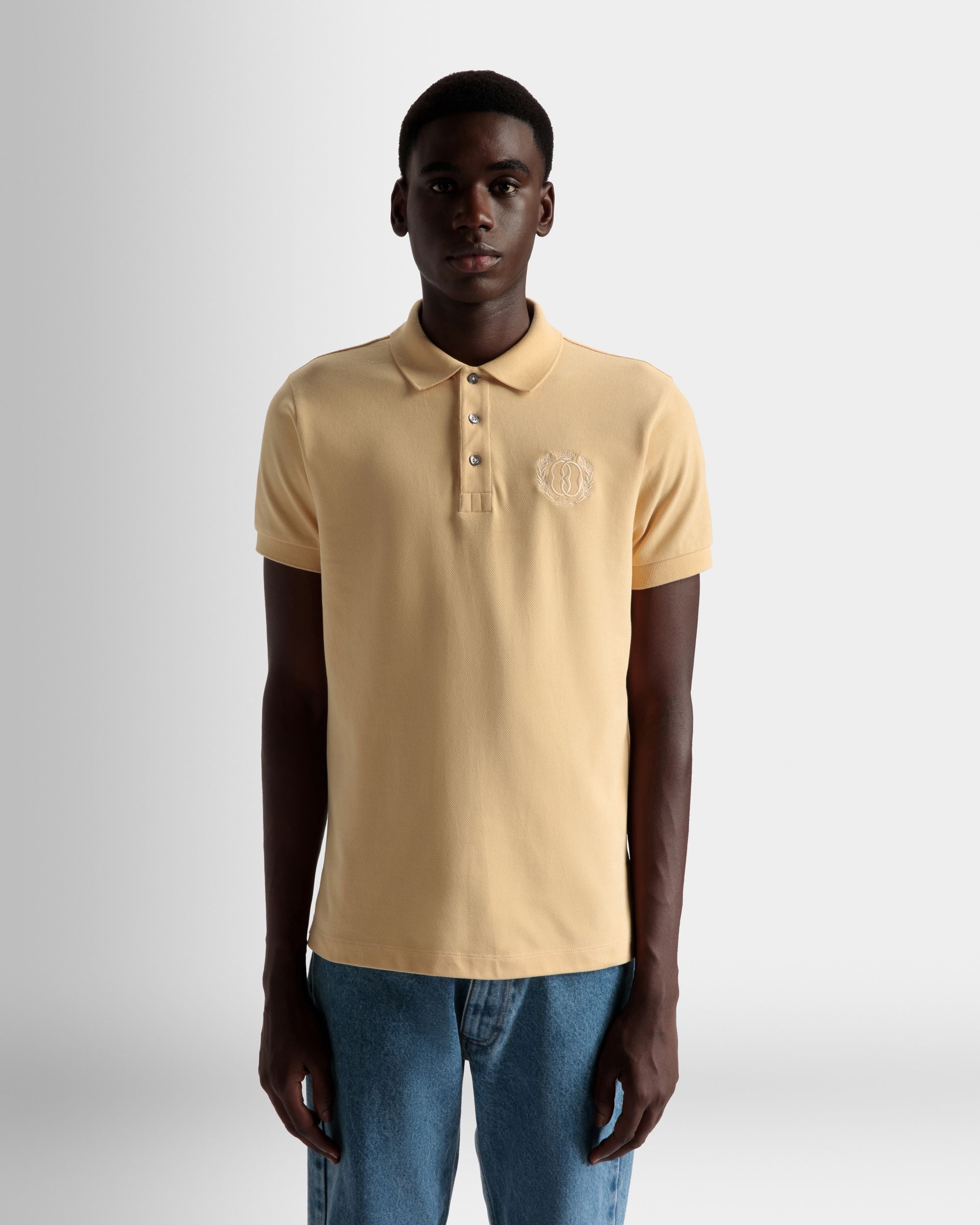 Emblem Poloshirt | Poloshirt für Herren | Cremefarbene Baumwolle | Bally | Model getragen Nahaufnahme