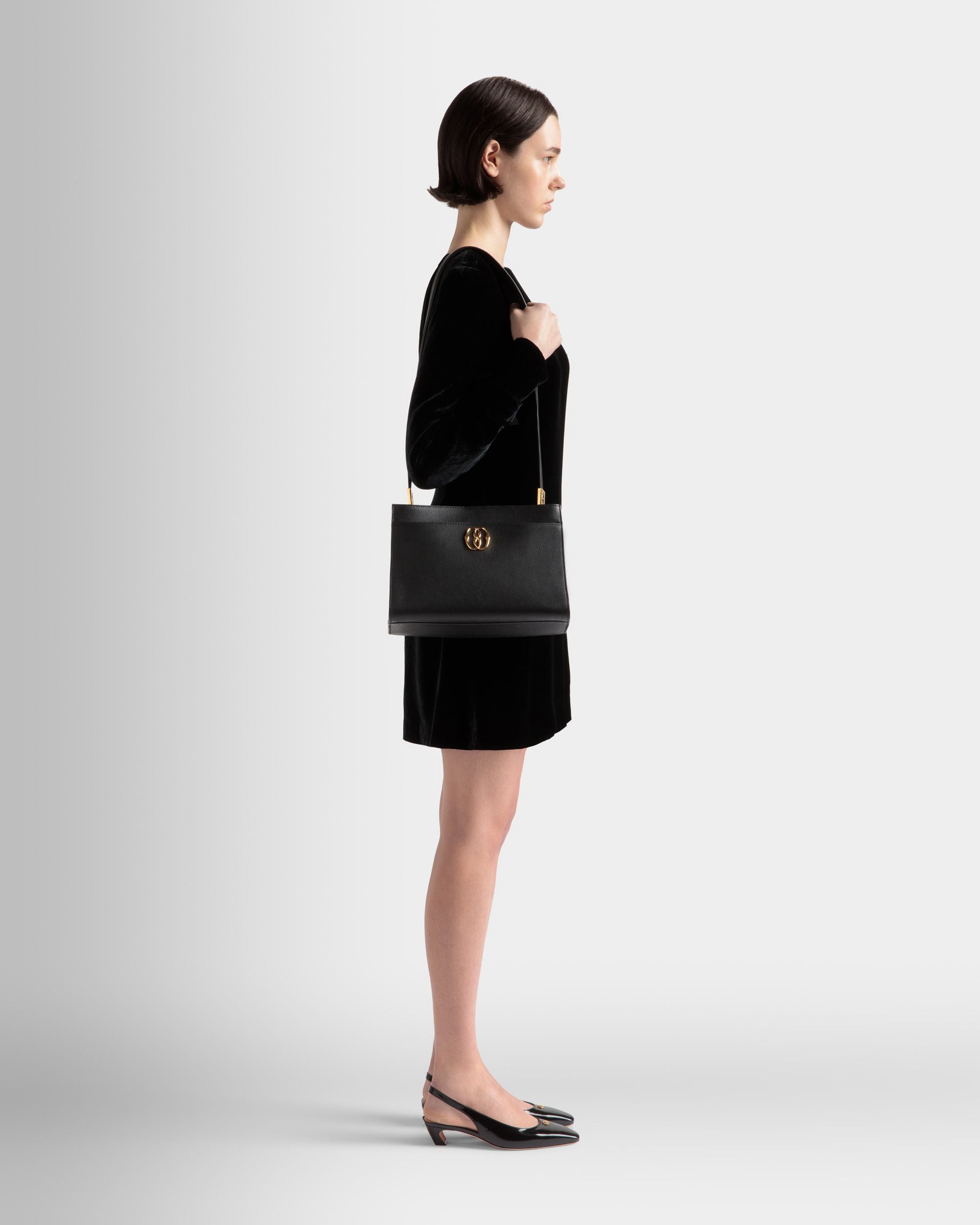 Emblem |  Schultertasche für Damen aus genarbtem Leder in Schwarz | Bally | Model getragen Vorderseite