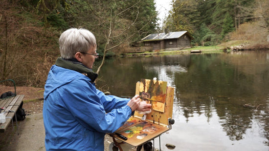 Artist Sheree Jones paints outdoors at a lake.