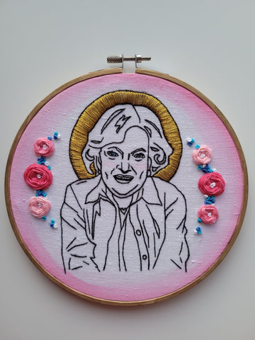 Betty white hoop, showcasing the use of French knots in the woven wheels stitch as well as added texture alongside the flowers