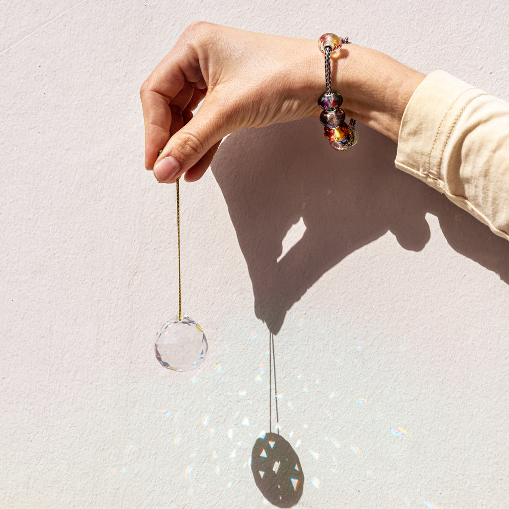 Trollbeads Suncatcher held by model wearing reflection glass beads