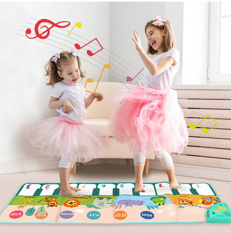 A colorful musical floor piano mat with large, colorful keys, showing a child playing with their feet.