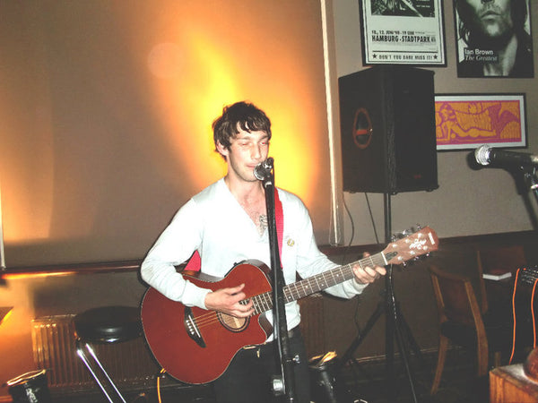 Stu playing guitar at a gig
