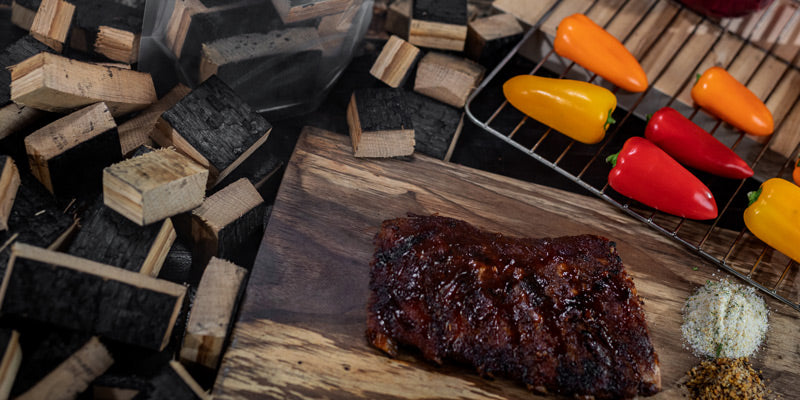 Smoked meat, peppers, salt and pepper and dry rub near bourbon barrel BBQ smoking wood chunks