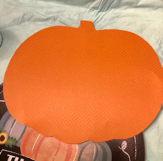 An orange pumpkin shape cut out of cardstock.