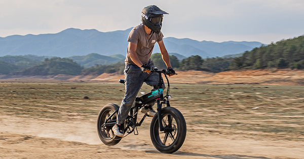 Mann fährt Elektrofahrrad auf Sand