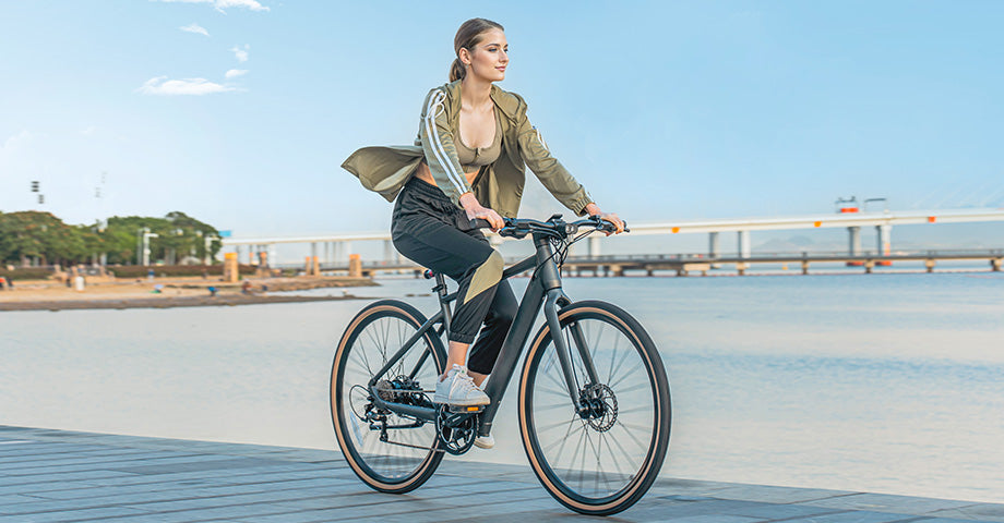 Frau fährt mit Elektrofahrrad am See