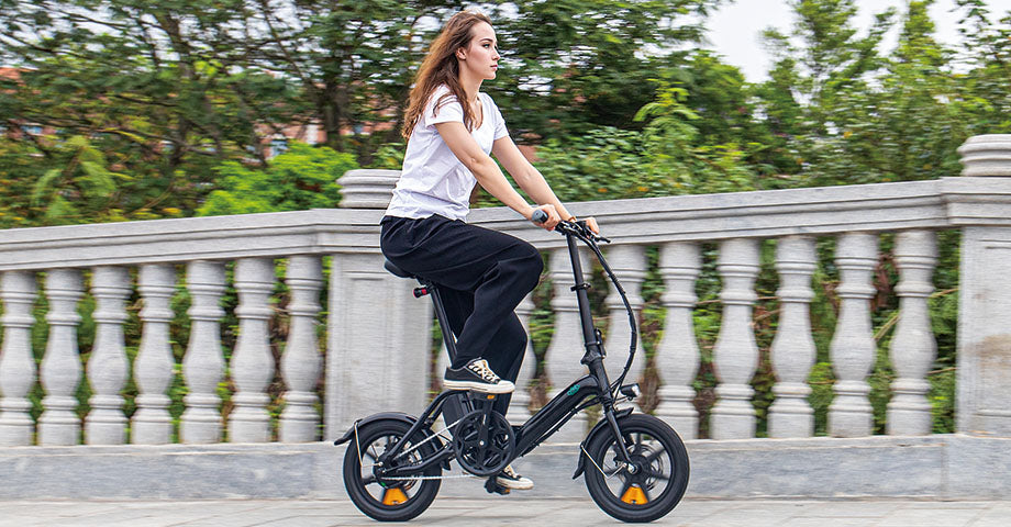 Frau fährt mit dem Elektrofahrrad M1pro auf einer Brücke