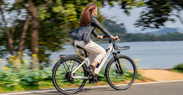 Frau fährt mit Elektrofahrrad am See