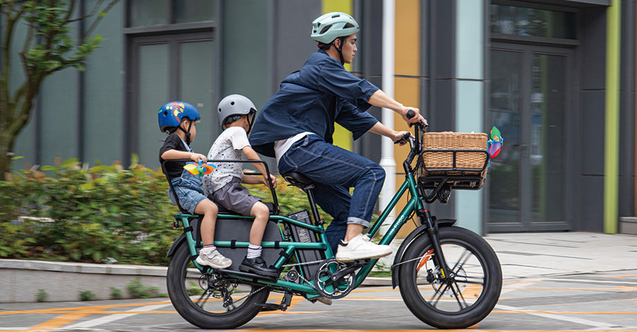 Ein Mann fährt mit einem Fiido T2 Elektrofahrrad um die Ecke und trägt zwei Kinder