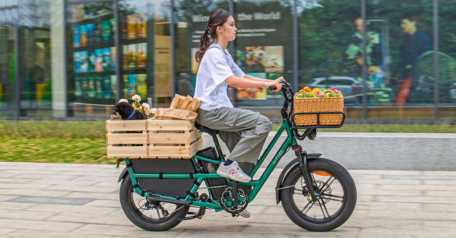 Eine Frau fährt mit einem Fiido T2 Longtail Cargo E-Bike durch den Block.