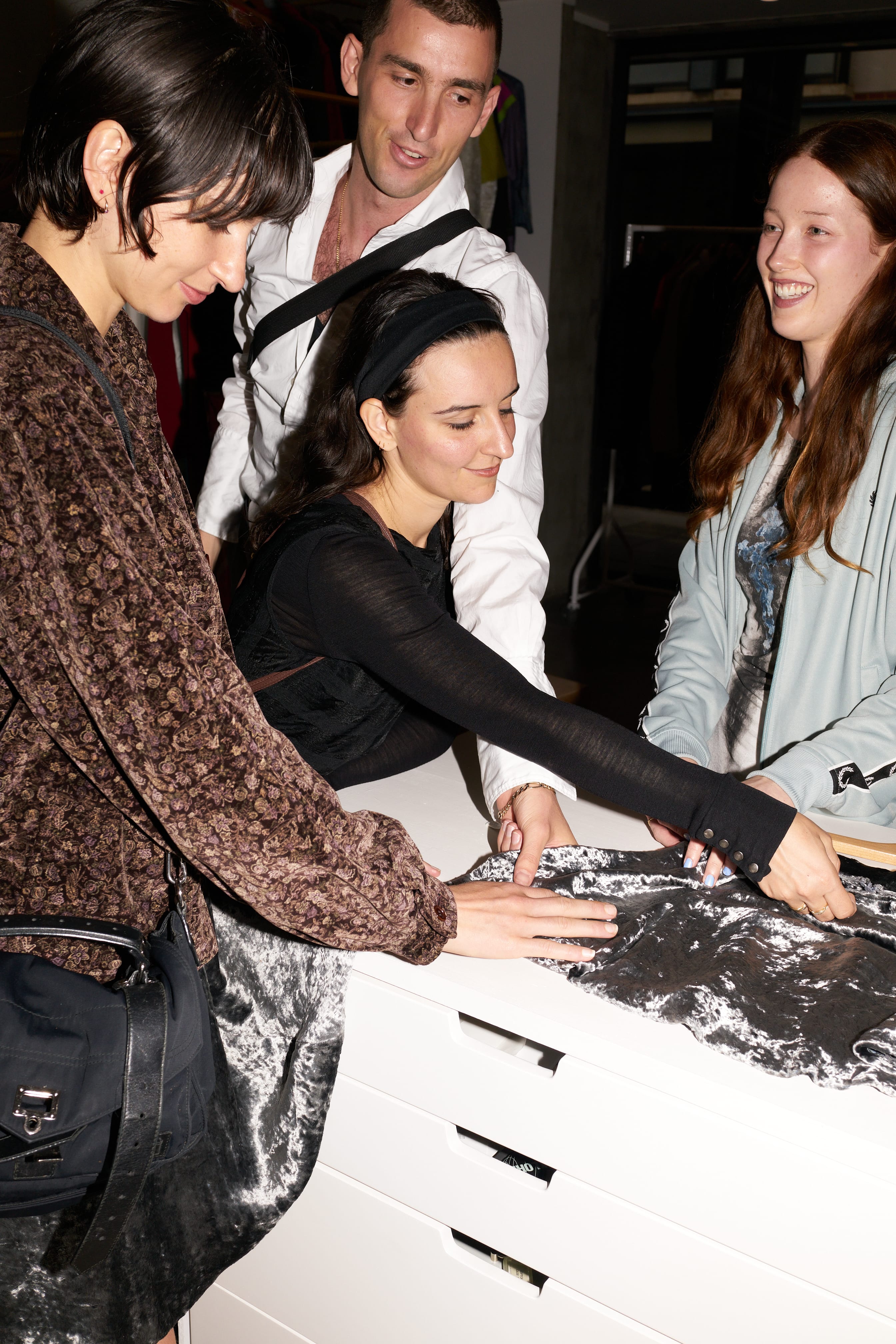 Clare, giuseppe, sarah, and sofia touching shiny silver velvet skirt by yoshiki hishinuma