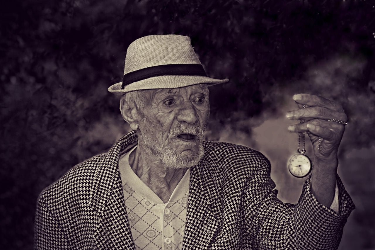 Painting of an old man holding a pocket watch