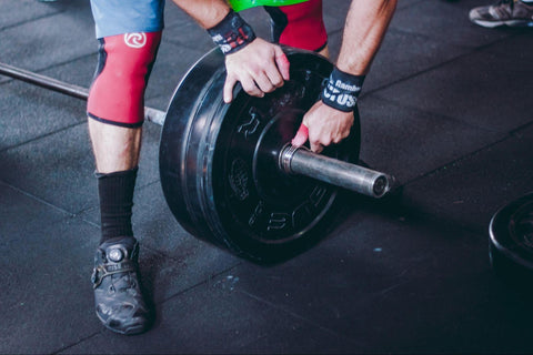 person putting weight on a barbell