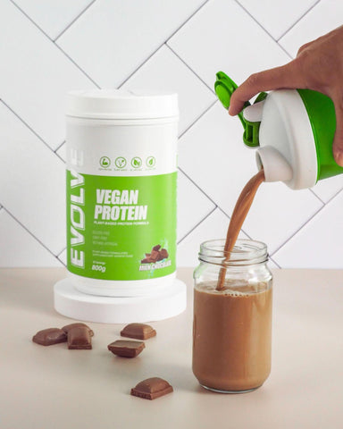 someone using protein powder to make a shake