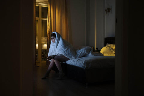 a person watching TV at night