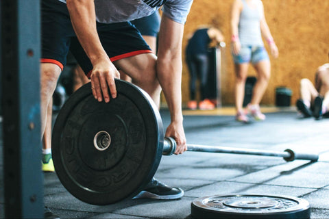 a person putting weight on a barbell