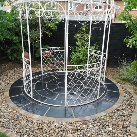 black limestone paving circle kit with a white metal decorative cage style pergola