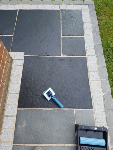 small black limestone patio with some slabs sealed and some not