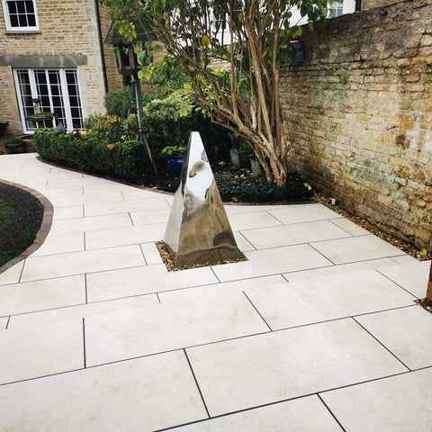 riva cream porcelain patio with a metalic silver pyramid ornament installed into the middle