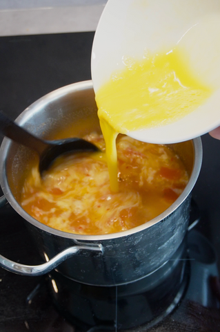 Pouring eggs into soup