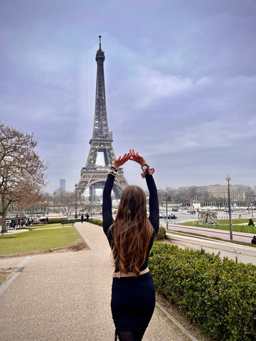 girl posing with scrunchies on her wrist in front of eiffel tower