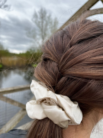 beige scrunchie being used to tie up woman's plaited hair