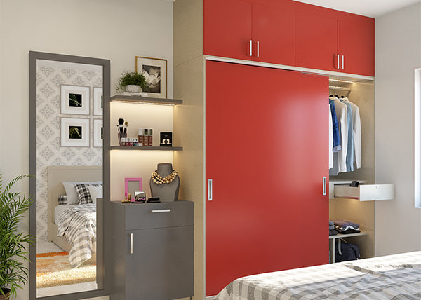Red laminate finish sliding wardrobe design with dressing table