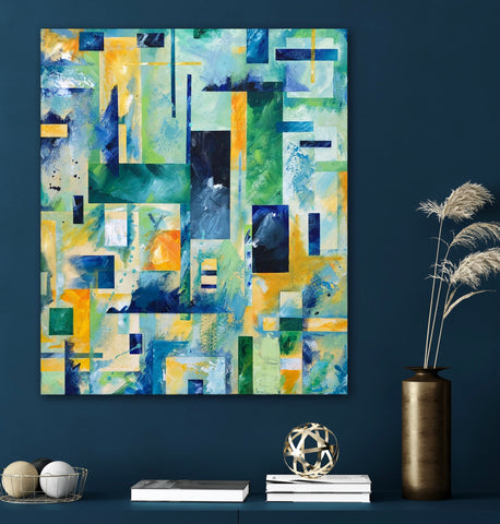 A commissioned abstract geometric acrylic painting in greens, blues and yellows displayed against a navy blue wall.