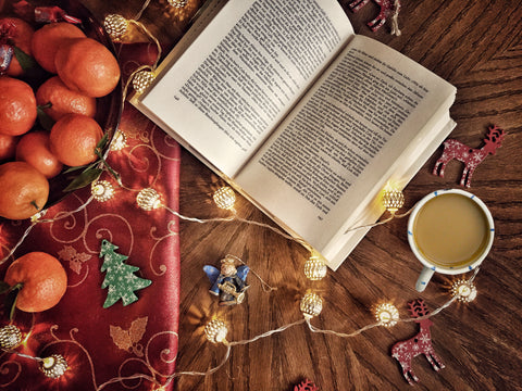 Coffee with milk sitting beside a book and christmas decorations