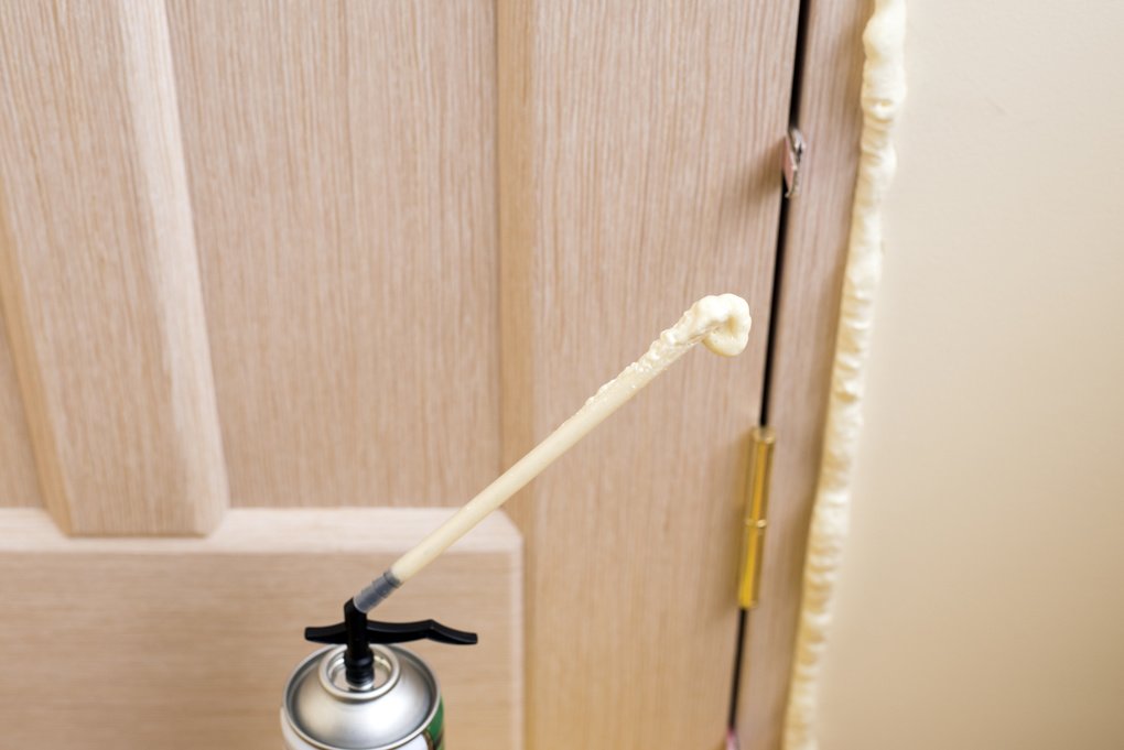 Foam insulation overspray around an interior door mounting will require foam cutting tools to remove it prior to painting.