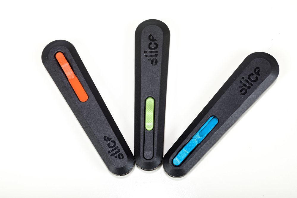 A fanned-out selection of Slice® retractable knives with color-coded sliders.