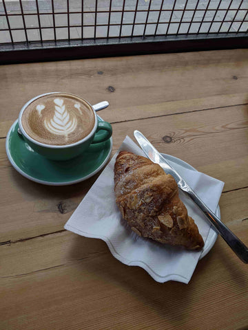 cup of coffee and almond croissant