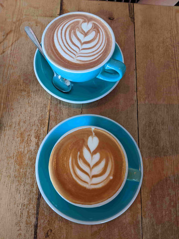 two cups of coffee in light blue cups with matching saucers