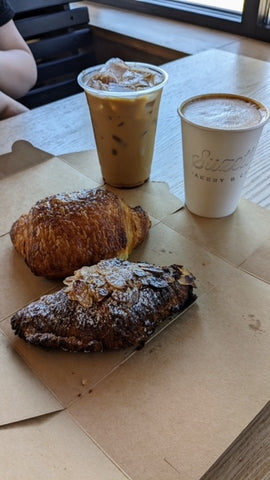 chocolate croissant and almond croissant with an iced coffee and a hot latte