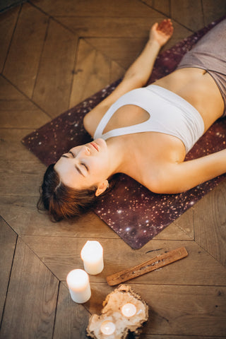 Women meditating on yoga mat lying down