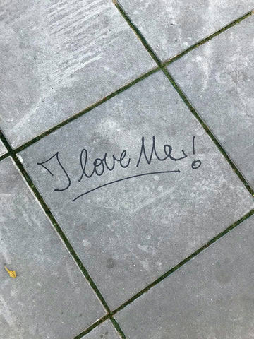 "I love me!" written on grey tiles