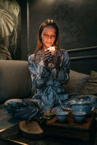 Woman in pyjamas holding a candle