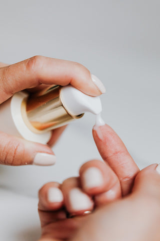 Female hands pumping sunscreen out of bottle