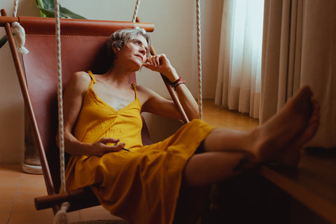 Woman in swing chair looking out of her window