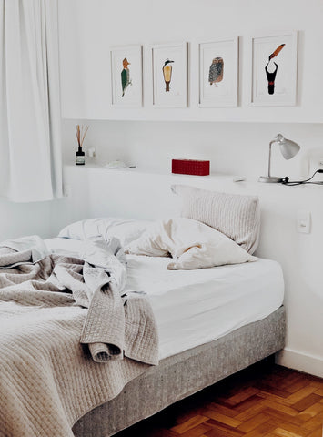 A white bedroom with an unkempt bed