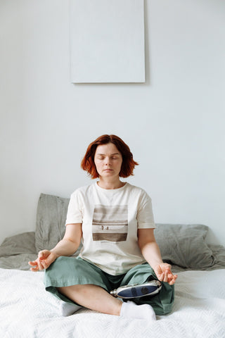 Women meditating on her bed