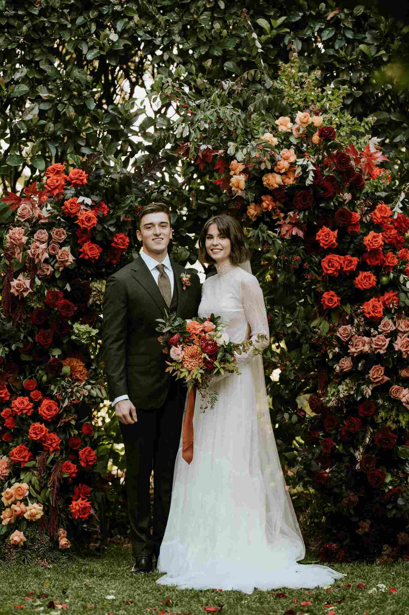 Bonnie and Taylor's portrait in front of autumnal themed arbour