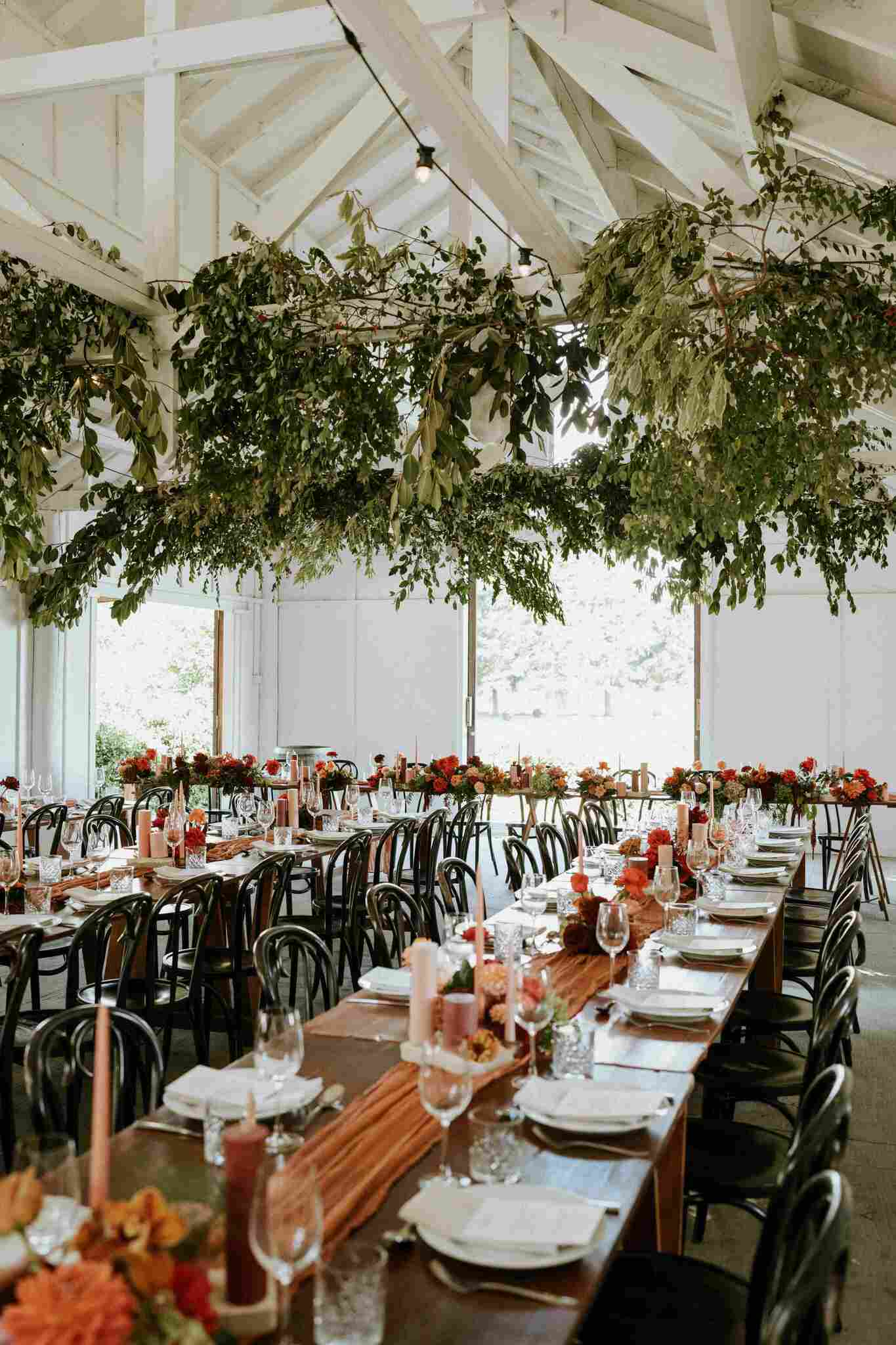 Bonnie and Taylor's wedding reception with long table decorated with garden greens