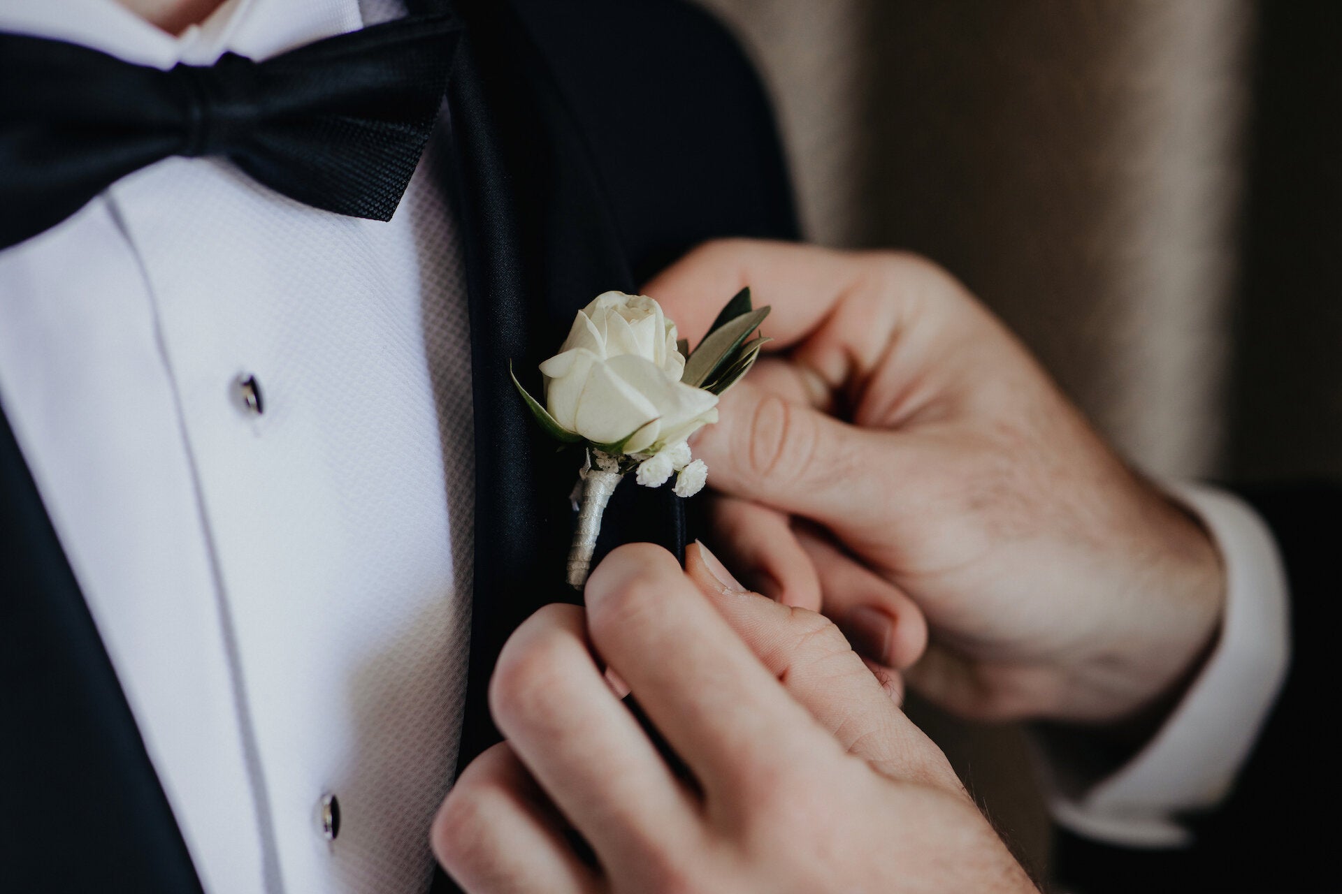 Grooms buttonhole with white rose and olive leaf.