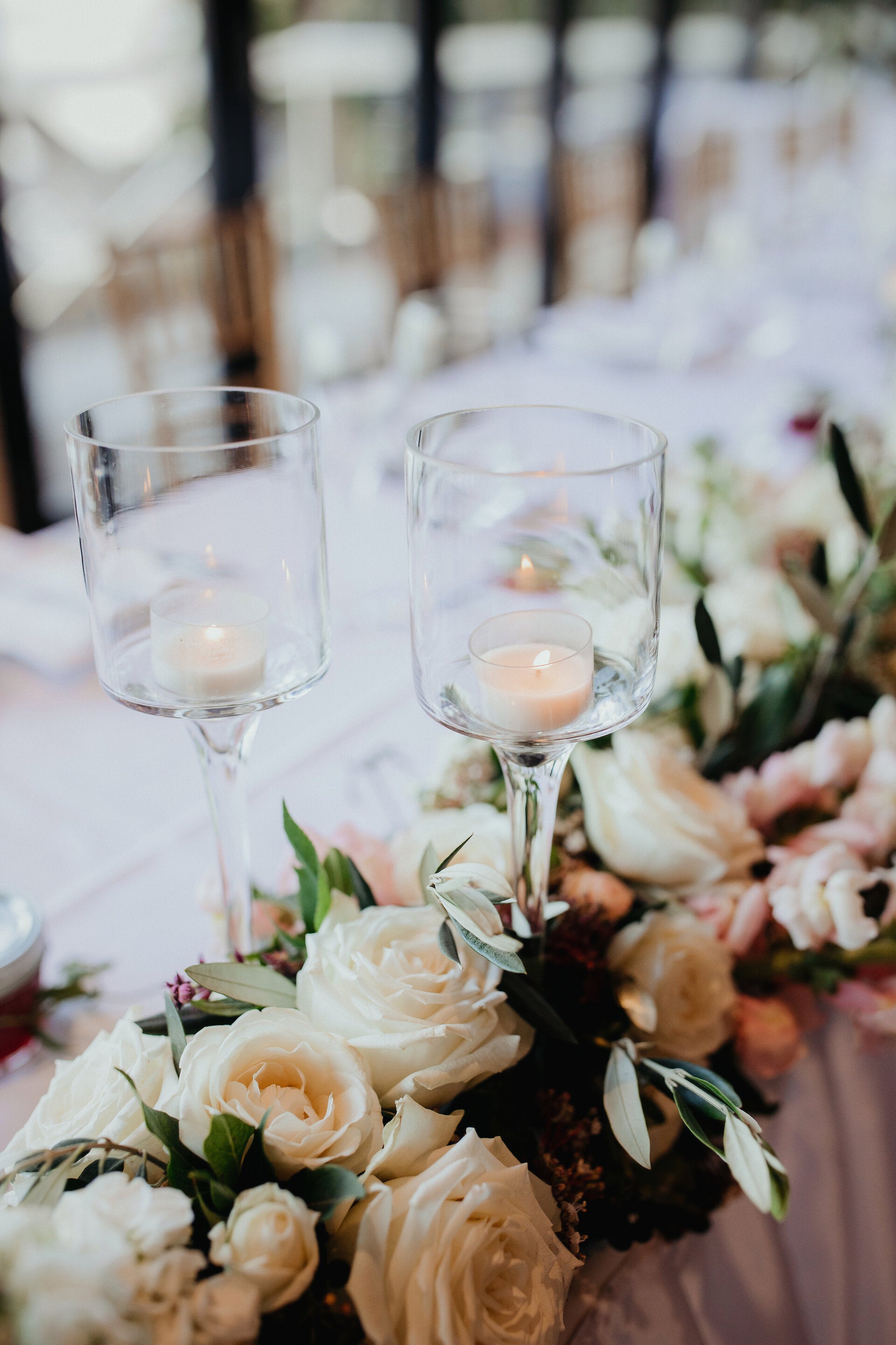 Bridal table floral garland with stem glass candleholders for a wedding reception at Pee Wees
