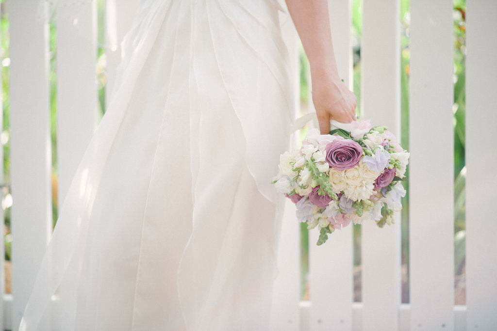 a bride in a wedding dress holding a hand tied bouquet of flowers from beija flor