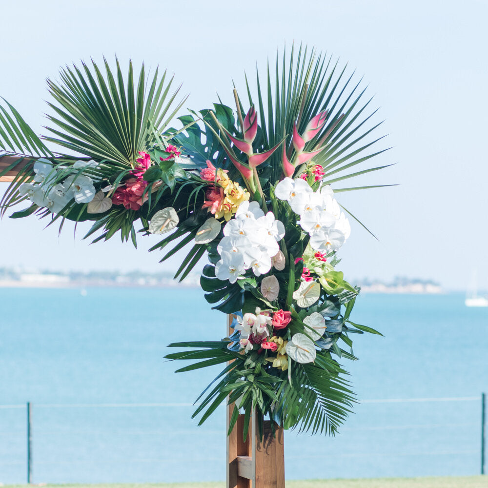 a tall wooden pole of arbour with a bunch of flowers on top