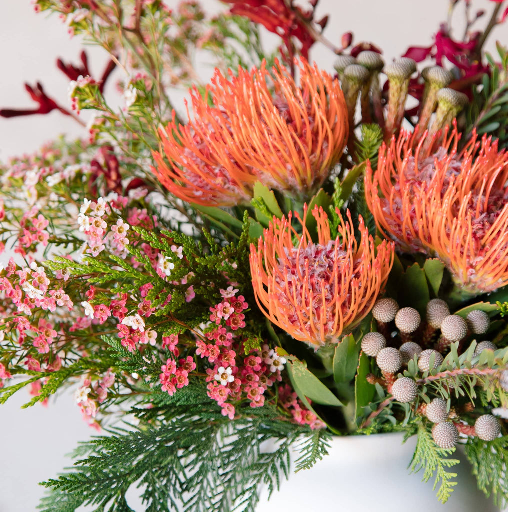 beija flor vase arrangement with the signature orange pin cushion protea