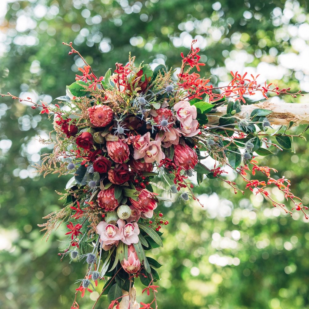 wedding arbour floral piece in burgundy, pink and blue flowers